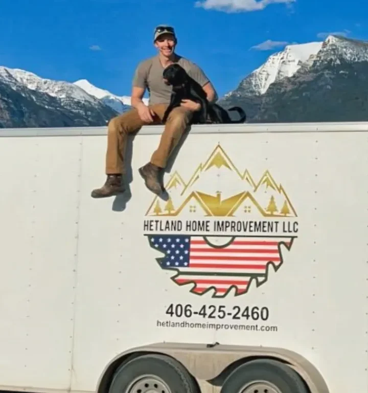 Contractor sitting on top of a service trailer with a dog in Missoula MT.