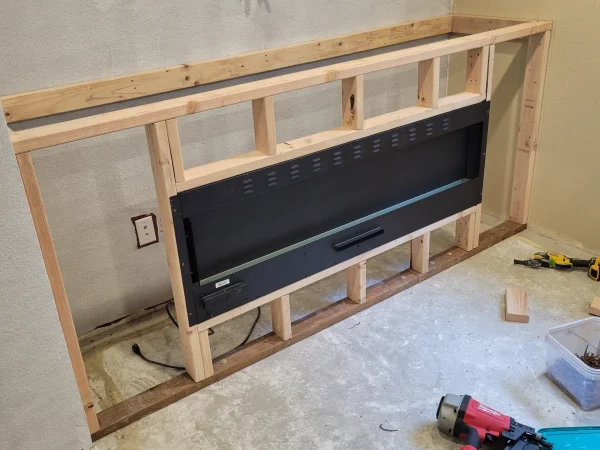Framing for a custom fireplace and TV bump-out in a Missoula basement remodel.