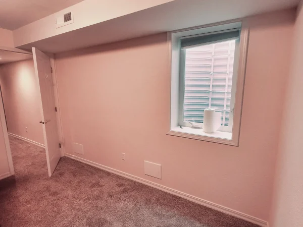 Finished basement room with an egress window and reinstalled carpet in Missoula.