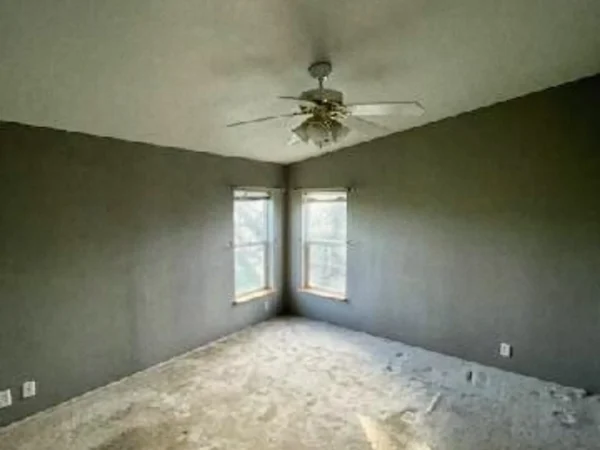 Finished bedroom with grey walls, white ceiling, and a new ceiling fan.