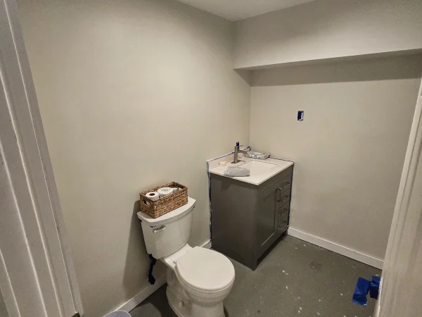 Finished half-bathroom with grey vanity and white toilet in Missoula.