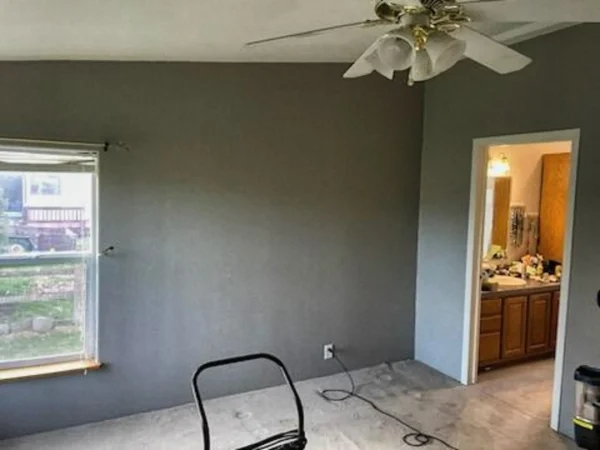 Bedroom walls painted grey with white window trim and a finished ceiling.