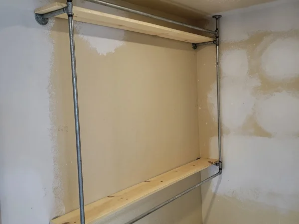Detail of industrial galvanized pipe shelving used for closet organization in Missoula.