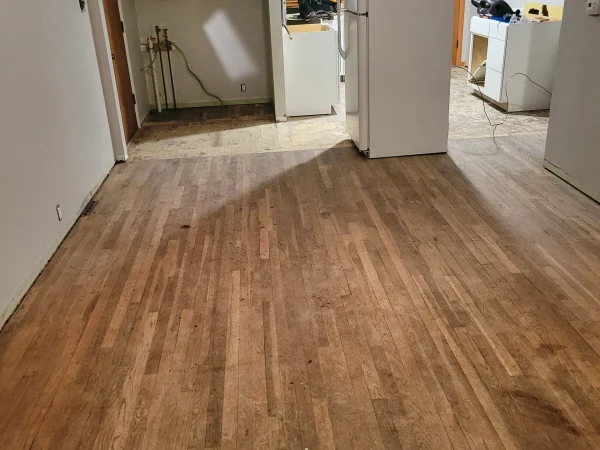 Kitchen and living area before LVP flooring installation in Missoula.