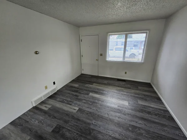 Living room featuring new LVP flooring and fresh white paint in Missoula.