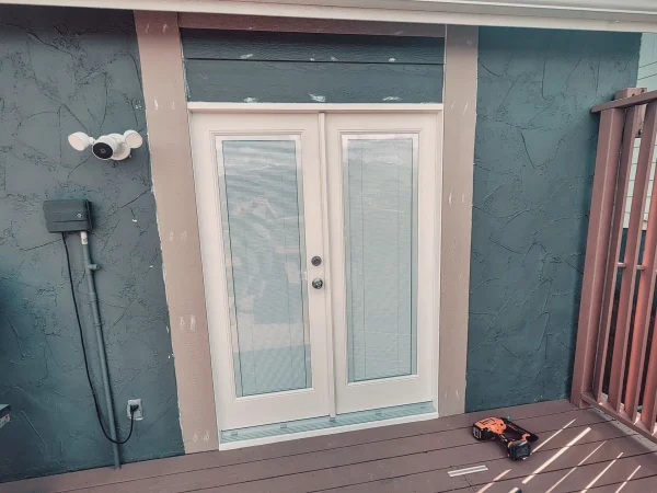 Exterior view of newly installed white French patio doors with in-glass blinds