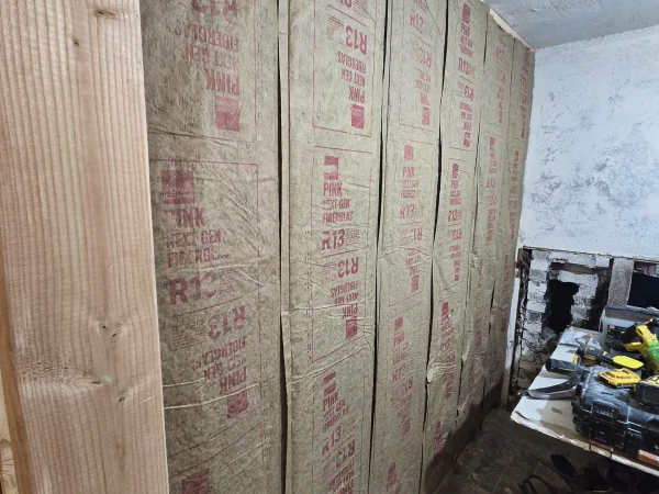 Fiberglass batt insulation installed in new interior wall framing.