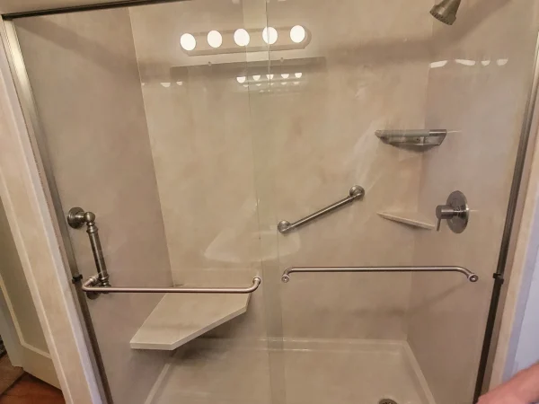 Sliding glass shower door with interior bench and grab bar in Missoula.