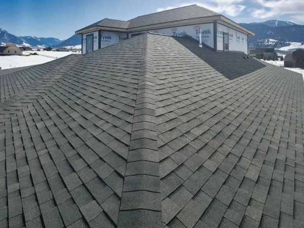Detail shot of staggered asphalt shingles and ridge caps on a hip roof in Missoula.
