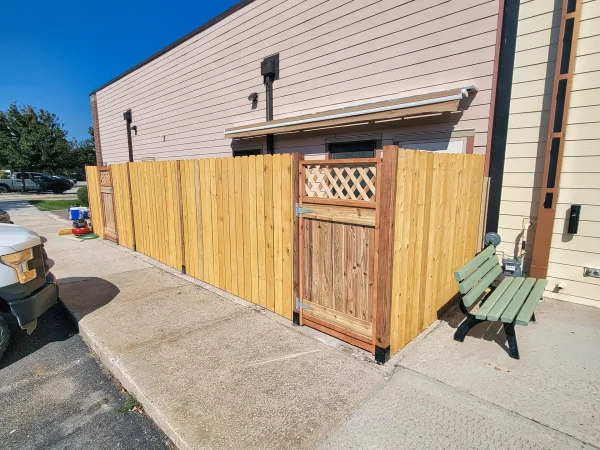 Surface-mounted wood picket fence on concrete sidewalk in Missoula.