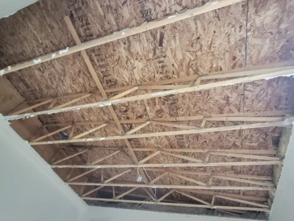 Raw roof trusses and OSB sheathing before ceiling restoration on Mullan Road, Missoula.