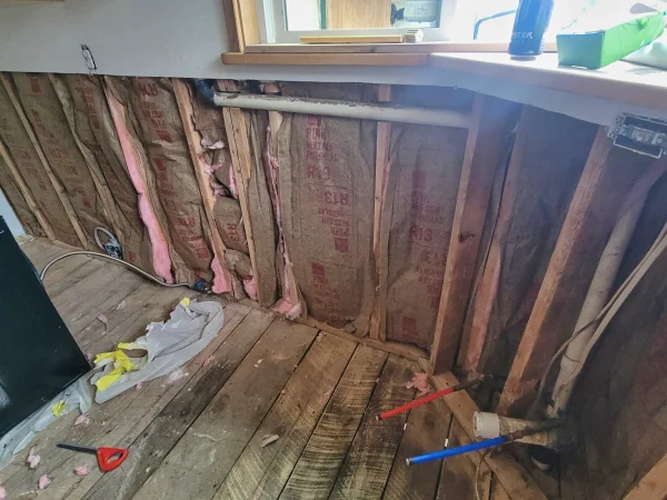 Exposed wall cavities receiving new insulation