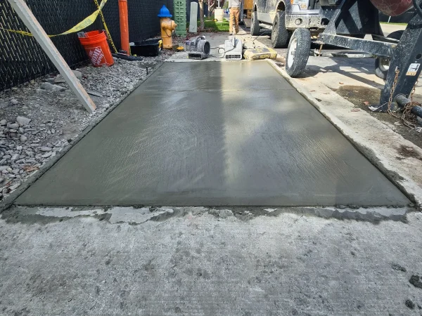 Freshly poured wet concrete being leveled for a new sidewalk in Missoula.
